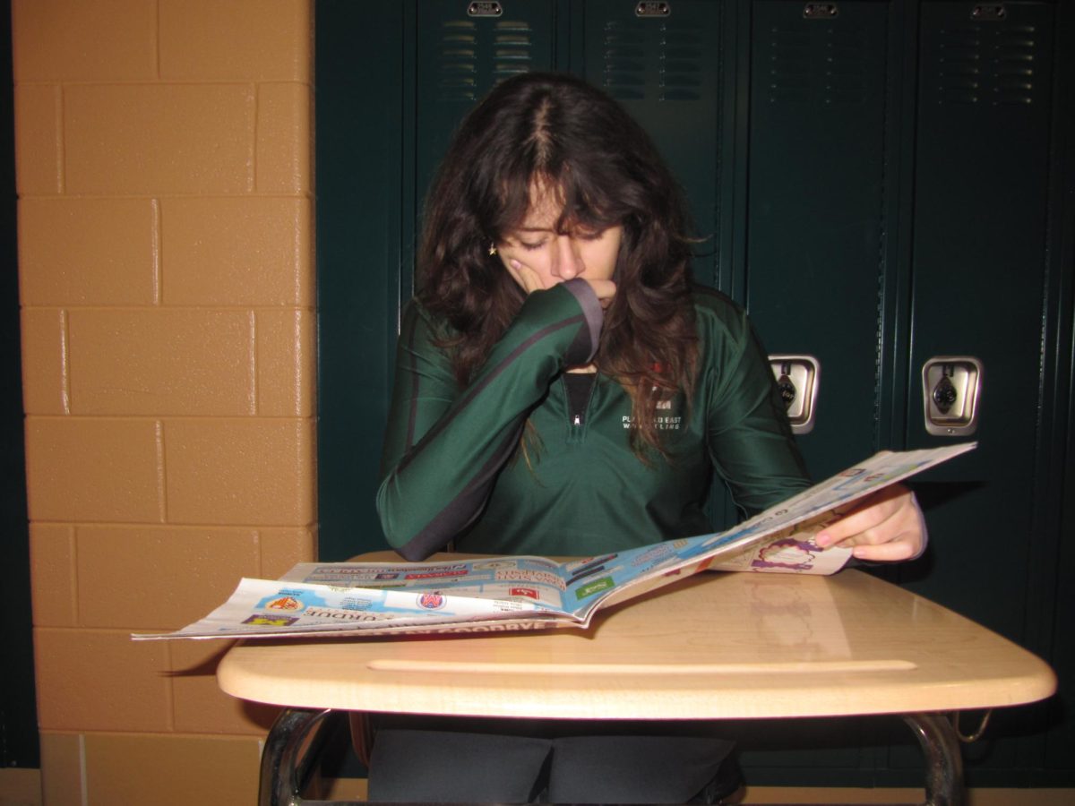 Junior Jennifer Serna inquisitively reading a newspaper, Dec. 12 2024.